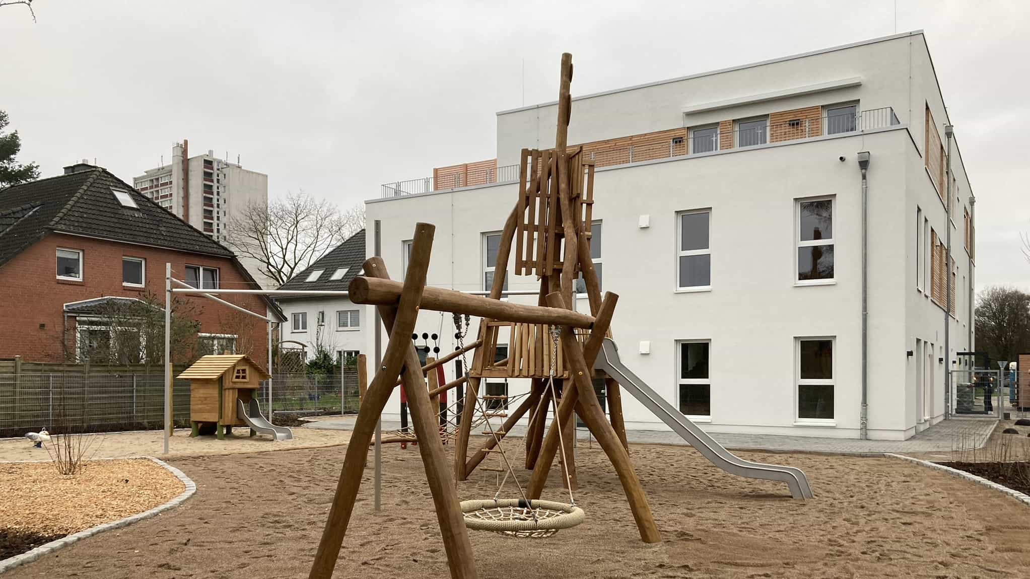 Dreigeschossige Kita KD3 von Haas Gewerbebau mit Staffelgeschoss und Holzkletterpyramide mit Rutsche
