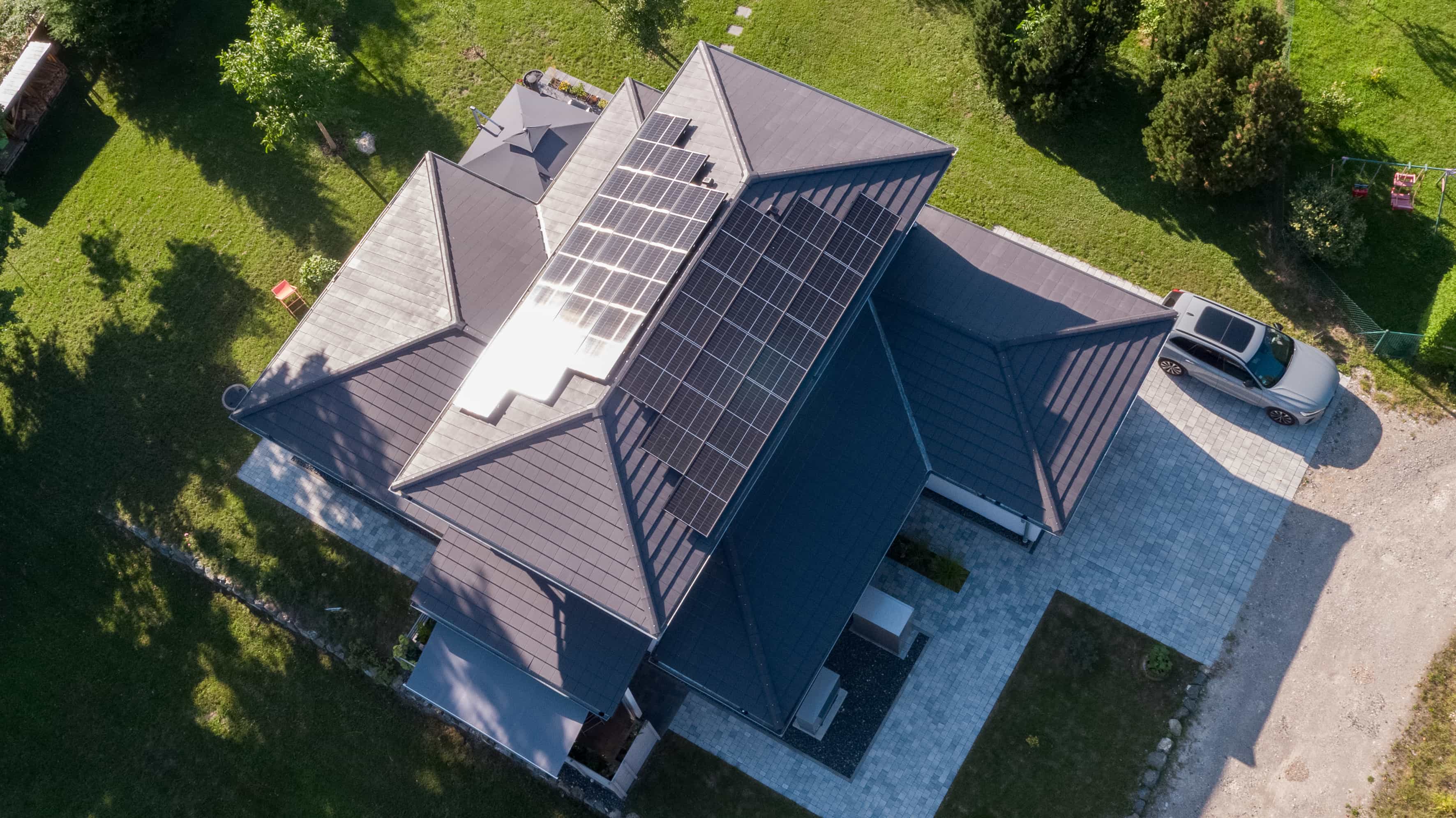 Luftaufnahme von oben auf das Walmdach mit Photovoltaik des Familienhauses Lampl von Haas