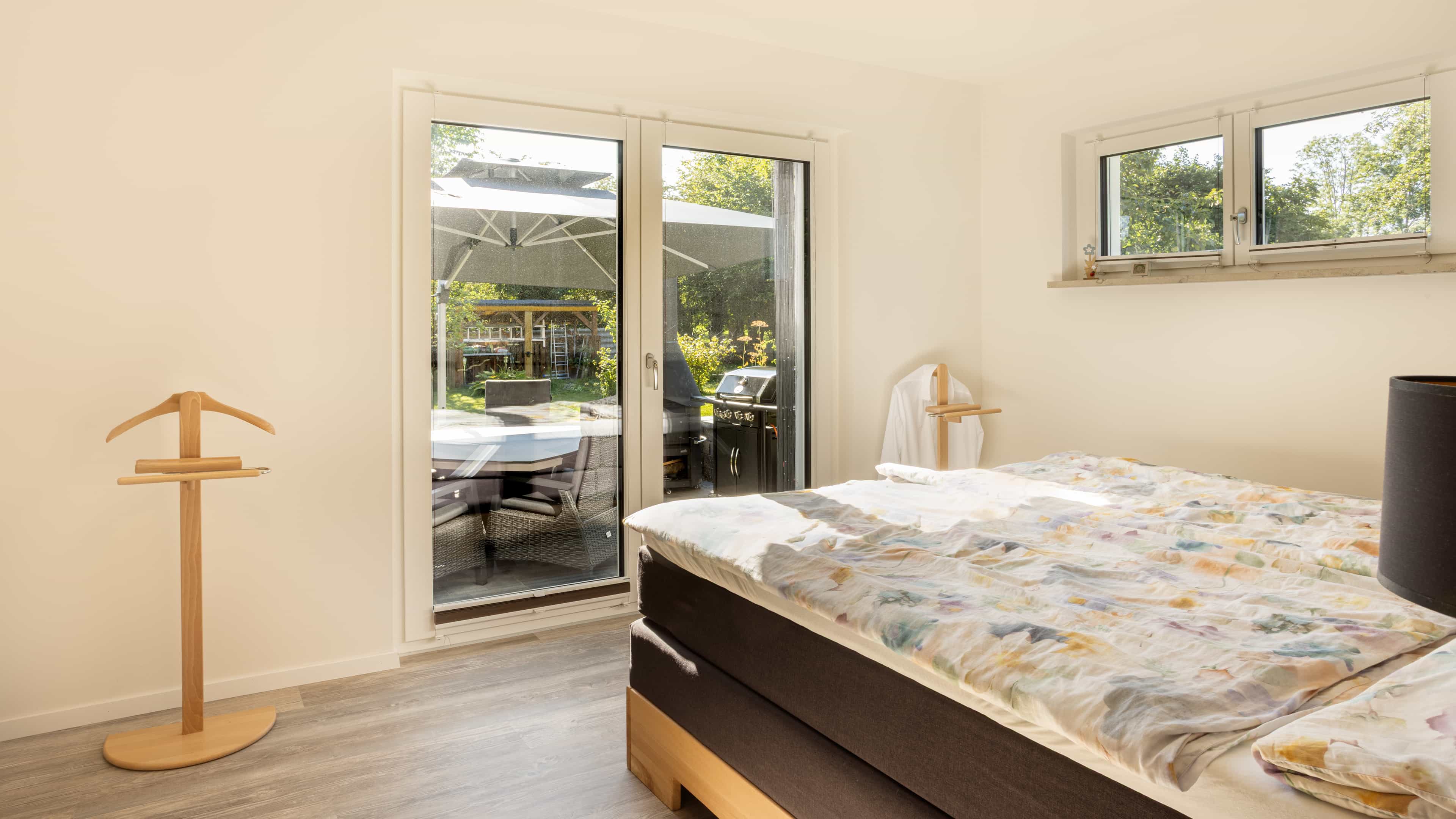 Schlafzimmer mit Doppelbett und Zugang zum Balkon im Familienhaus Lampl von Haas Fertigbau