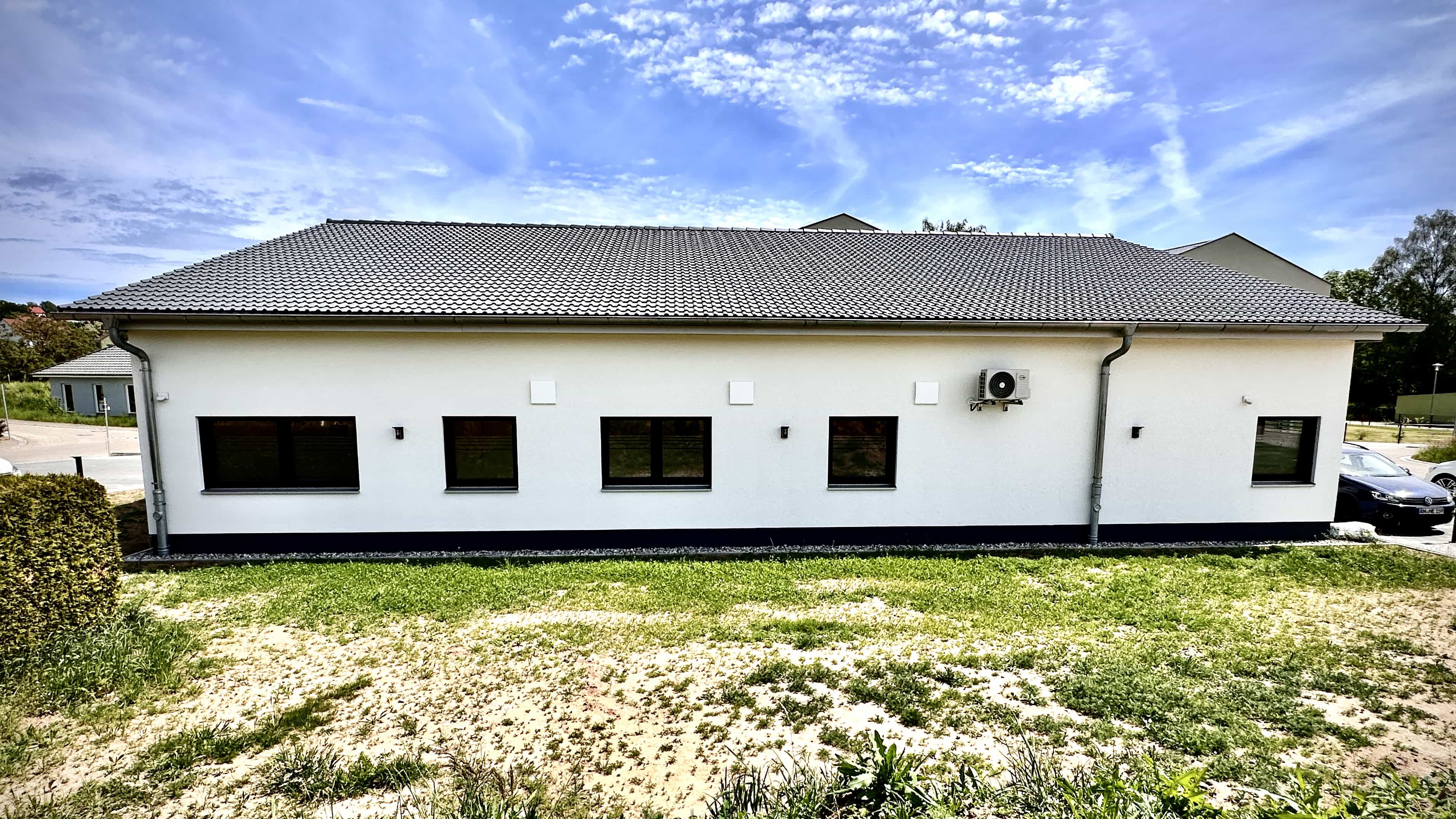 Rückseite des Praxisgebäudes Balzer mit Fensterreihe und Wiese von Haas Gewerbebau
