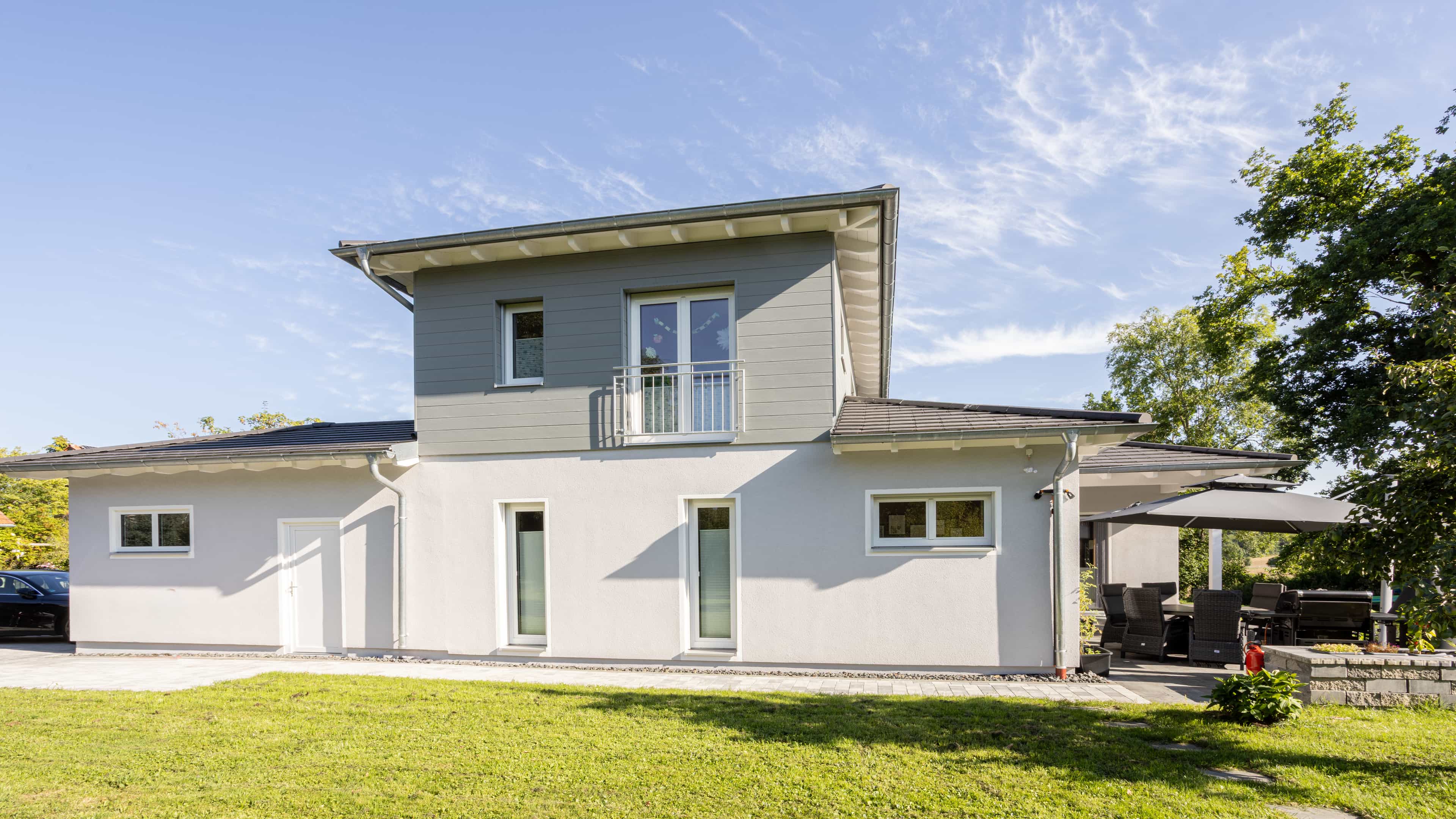 Familienhaus Lampl von der Gartenseite mit Staffelgeschoss, Balkon und Terrasse, Haas Fertighaus