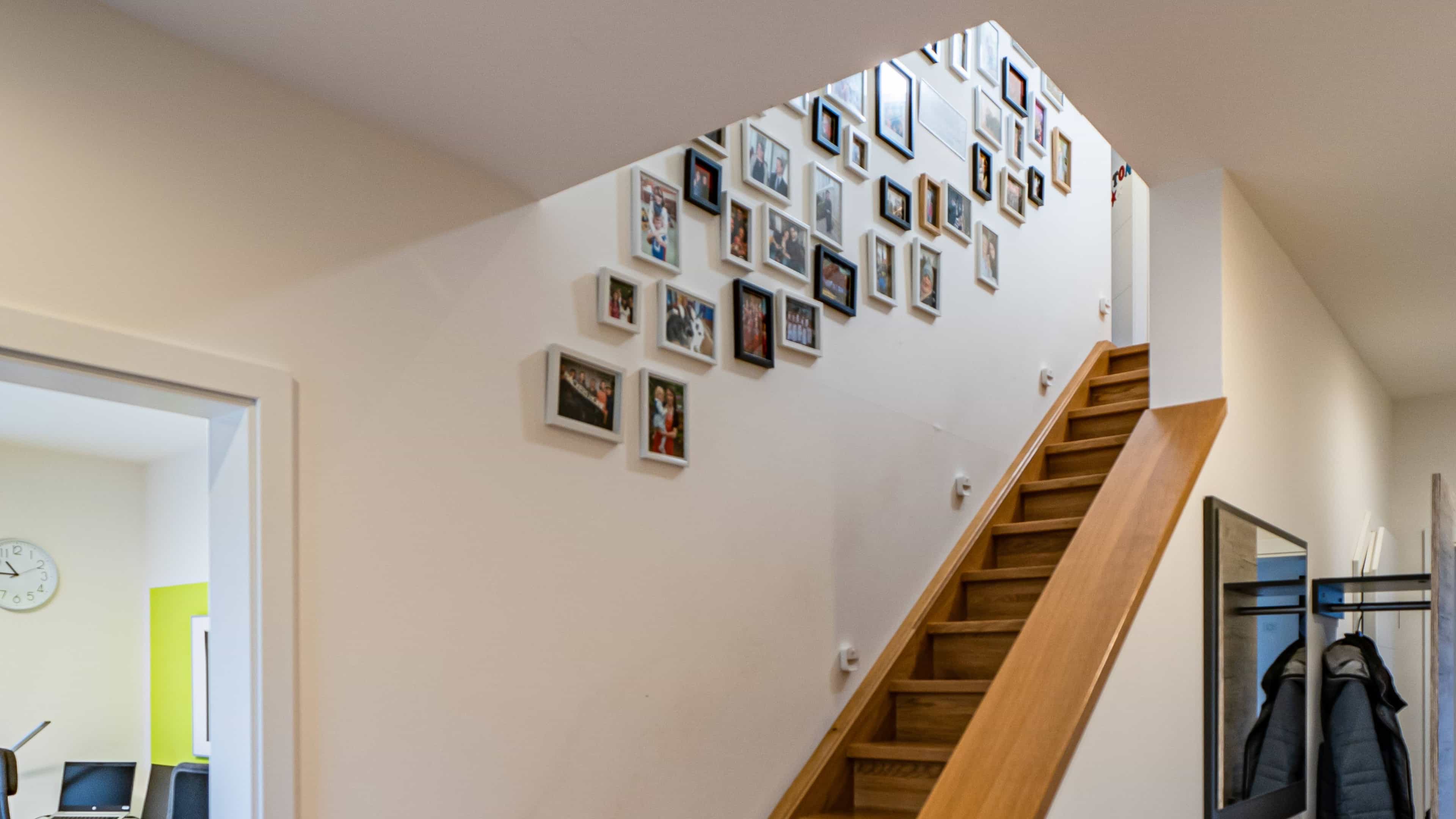 Treppe in einem Haus mit Fotowand, die mit verschiedenen gerahmten Bildern dekoriert ist.
