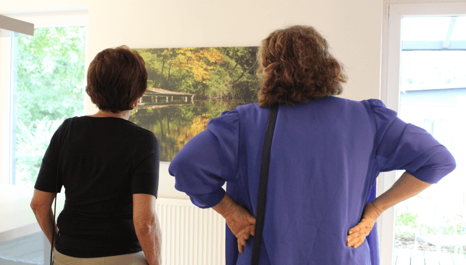 Bild zeigt v.l: Frau Marianne Haas senior und Cornelia Straubhaar-Tiffinger bei der Betrachtung einer Fotografie von Konrad Heuwieser auf der Vernissage der Kunstausstellung im Musterhauspark Falkenberg. © Haas Fertigbau GmbH, 2023