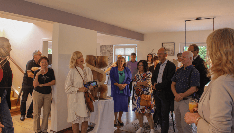 Bild zeigt: 1. Vorsitzende des Kunstvereins Altötting, Gerti Reitmeier und Besucher:innen der Vernissage Musterhauspark Falkenberg sowie Künstler:innen des Kunstvereins. © Haas Fertigbau GmbH, 2023