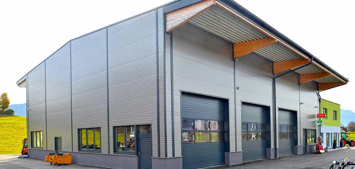 Werkstatthalle von Landtechnik Embacher mit Rolltoren und Vordach von Haas Gewerbebau