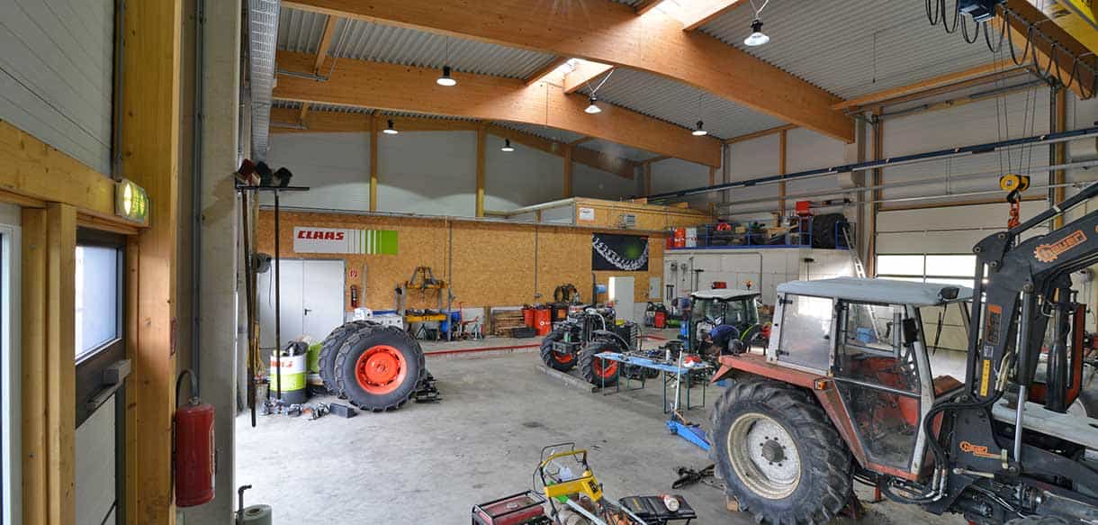 Werkstatthalle von Landtechnik Embacher mit Traktoren und Holzleimbindern