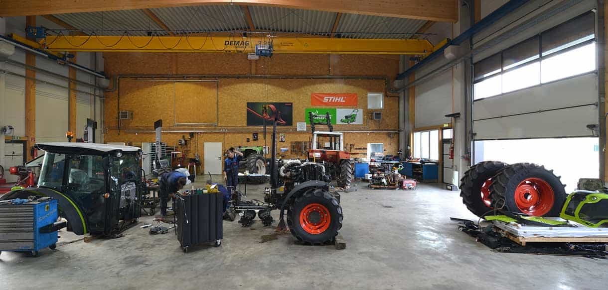 Werkstatthalle von Landtechnik Embacher mit Kranbahn, Traktoren und Hallentor