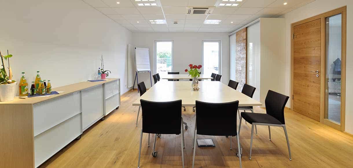 Besprechungsraum mit langem Tisch und Sideboard im Büro- und Laborgebäude von Explicat Pharma