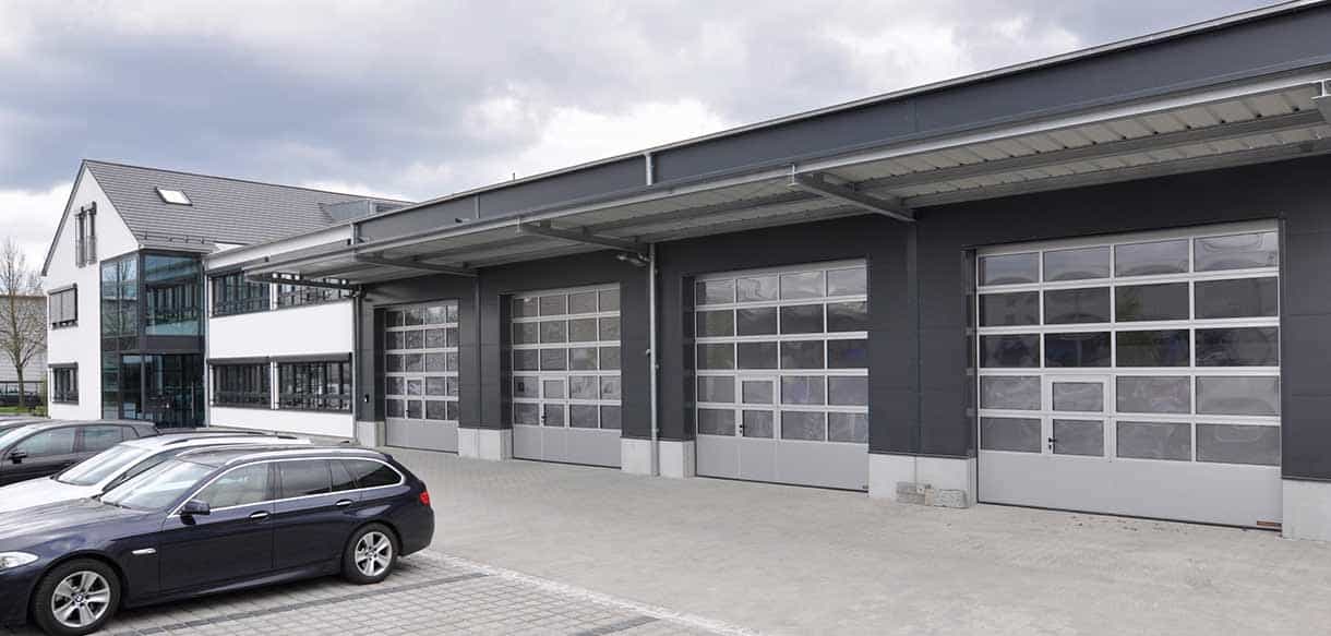 Lagerhalle mit Torreihe und angrenzendem Bürogebäude der Felden GmbH, Blick vom Hof