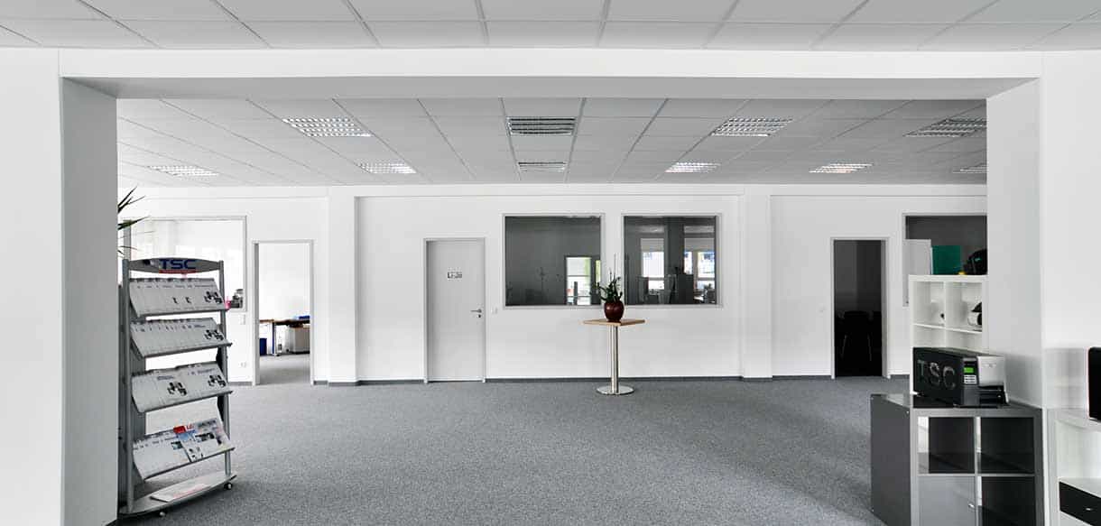 Offene Bürofläche mit grauem Teppich und Schränken im Bürogebäude der Felden GmbH