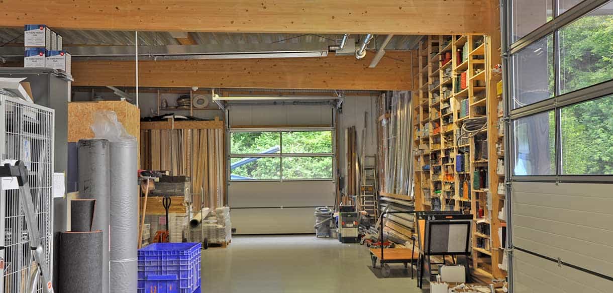 Lagerhalle von RM Bodenbeläge von innen mit Holzdecke, Regalen und Sektionaltor