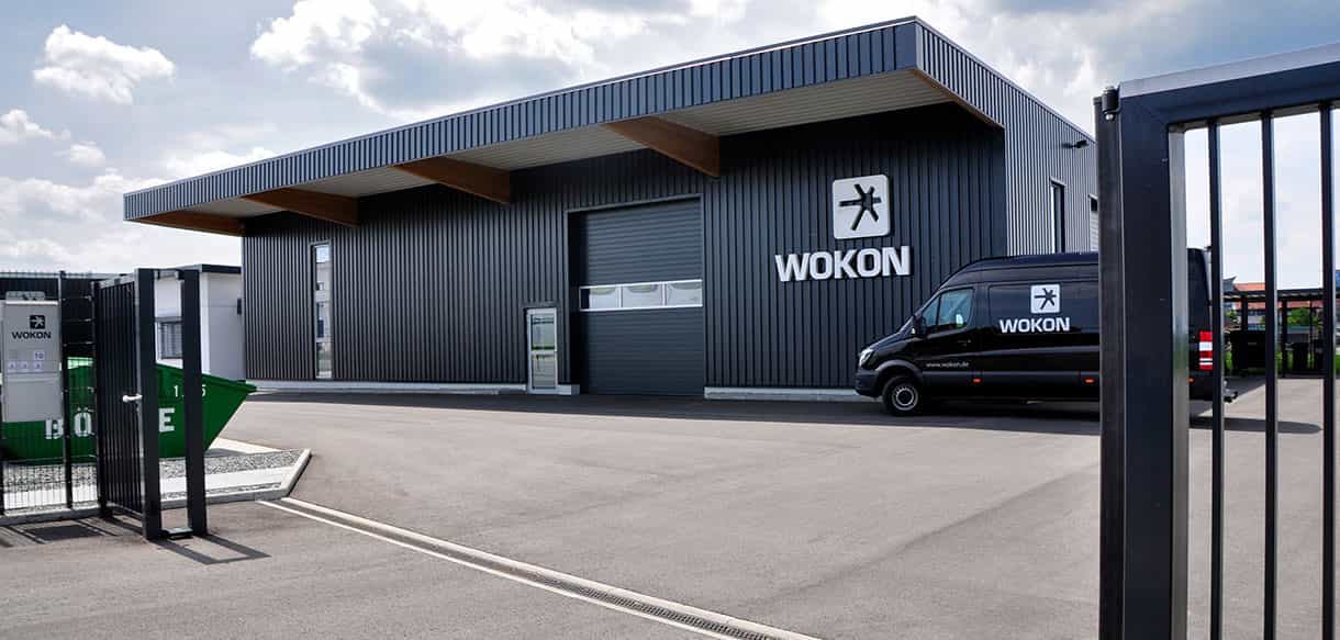 Eingangsbereich der Halle mit Büro von Wokon mit Firmenlogo, Vordach und Transporter, Haas Gewerbebau