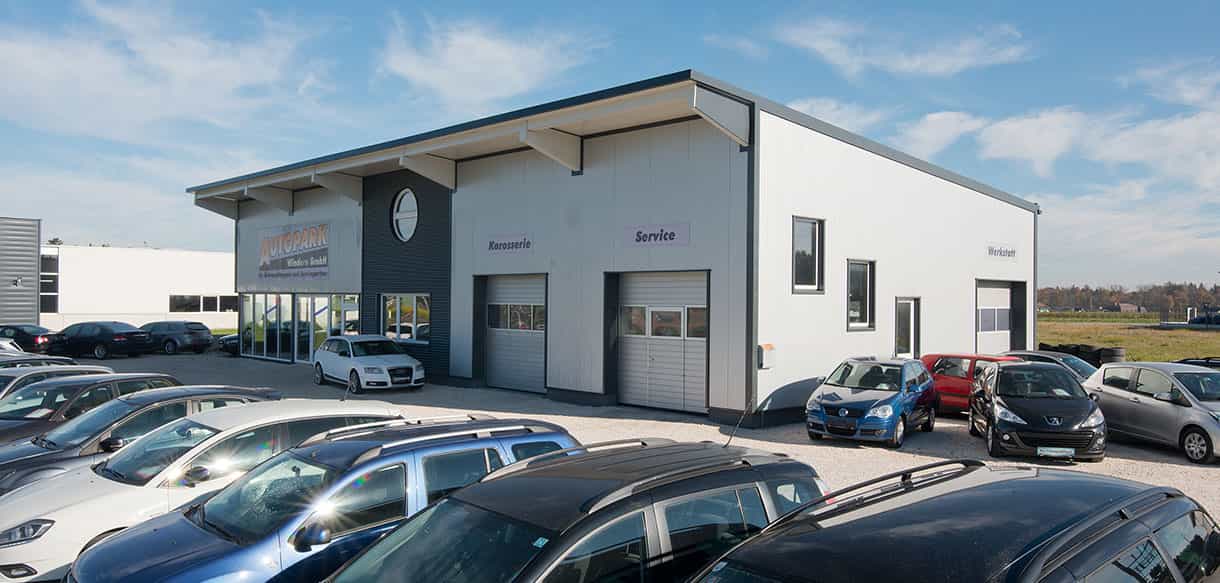 Kfz-Werkstatt mit Ausstellungsraum und Servicetoren von Autopark Windern, Gebrauchtwagen auf dem Vorplatz