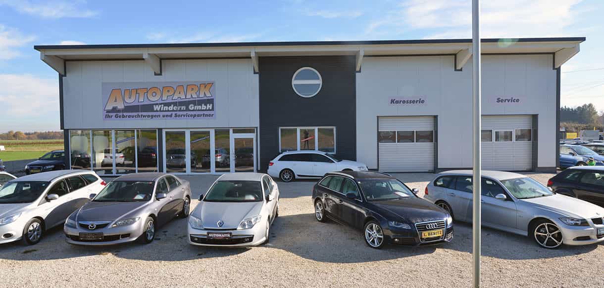 Frontansicht von Autopark Windern mit Firmenschild, Werkstatttoren und Gebrauchtwagen auf dem Vorplatz
