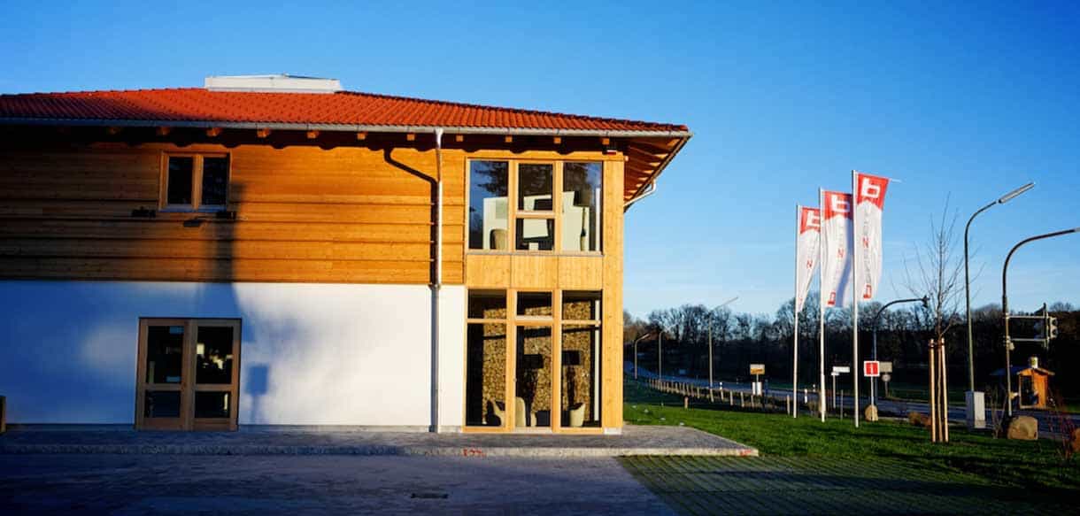 Verkaufsgebäude von Bergzeit Outdoor in Holzkirchen mit Holzfassade und verglastem Eingangsbereich, Außenansicht