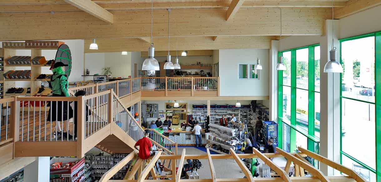Überblick über den Verkaufsraum mit Galerie, Holzdachkonstruktion und Glasfront bei Endel & Dietze