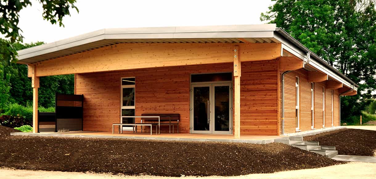 Ausstellungsgebäude aus Holz von Plössl und Söhne in Traunreut mit großer Terrassenüberdachung