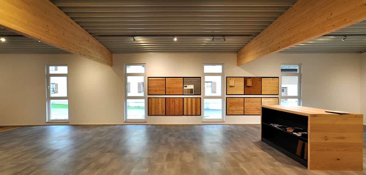 Ausstellungshalle von Plössl und Söhne mit Holzmusterwänden, Fenstern und Beratungstresen