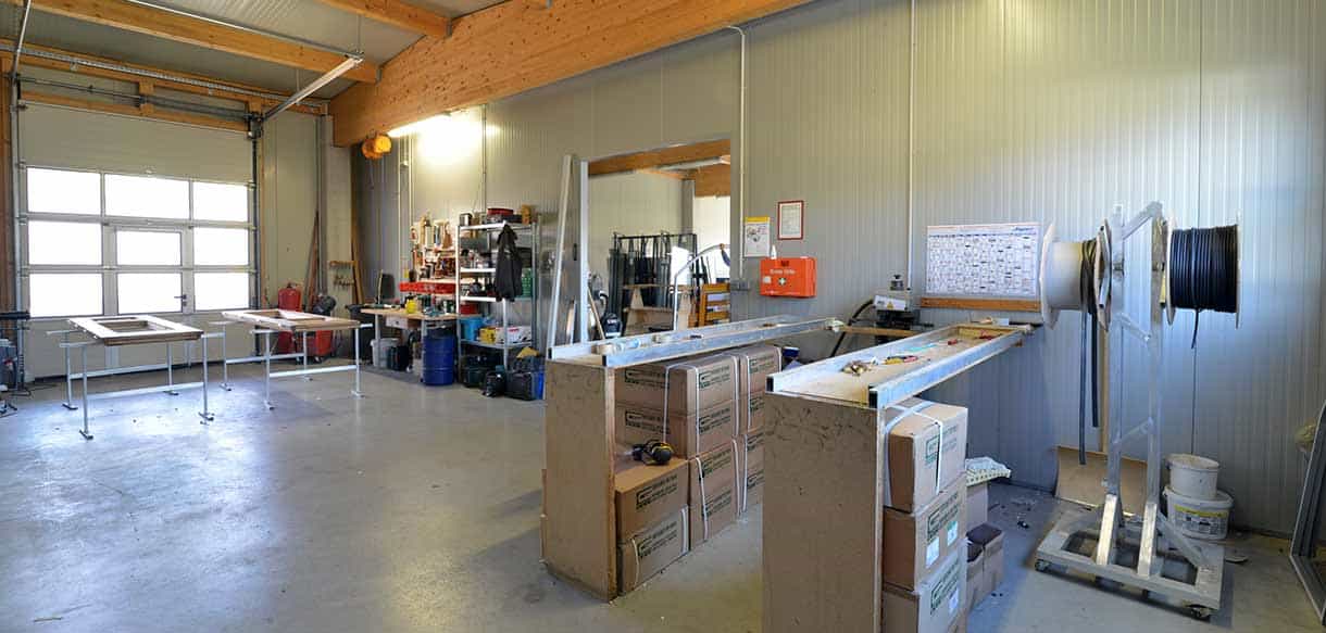 Werkbänke und Werkzeugstationen an der Hallenwand der Produktionshalle von Vorhauer mit Holzdachkonstruktion