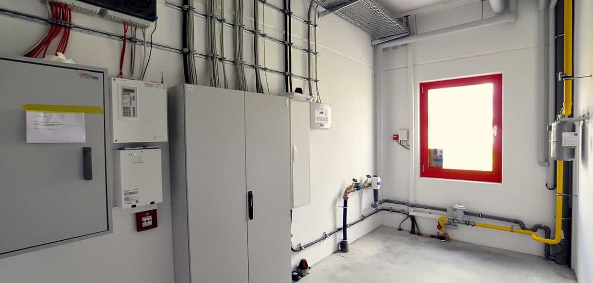 Elektroverteilung mit Schaltschränken und Gasleitung im Technikraum von Adler Lacke, Innenansicht
