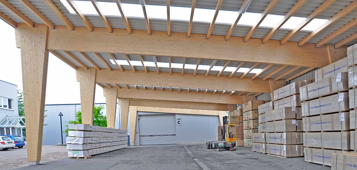 Überdachung mit Brettschichtholzstützen und gelagerten Platten an der Lagerhalle Jordan
