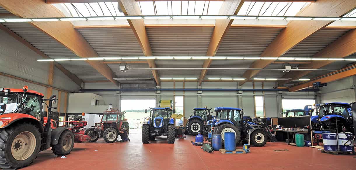 Werkstatthalle von Leinweber Landtechnik mit Traktoren, Oberlichtern und Holzbindern