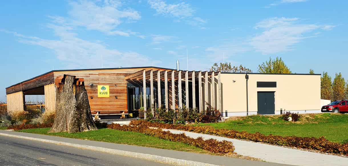 Gesamtansicht des KWB-Ausstellungsgebäudes mit Holzfassade und weißem Putzanbau