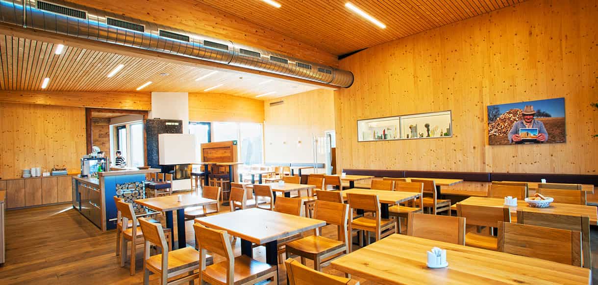 Gastraum mit Holztischen, Theke und Holzvertäfelung im KWB-Ausstellungsgebäude