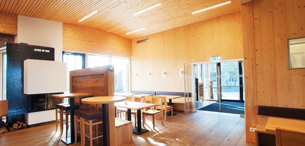 Kaminofen und Stehtische mit Blick zum Eingang im KWB-Ausstellungsgebäude