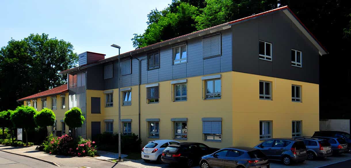 Aufgestocktes Bürogebäude der Kaiser GmbH mit gelber und grauer Fassade