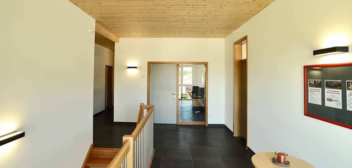 Flur mit Holzdecke und Treppengeländer im Obergeschoss des aufgestockten Bürogebäudes