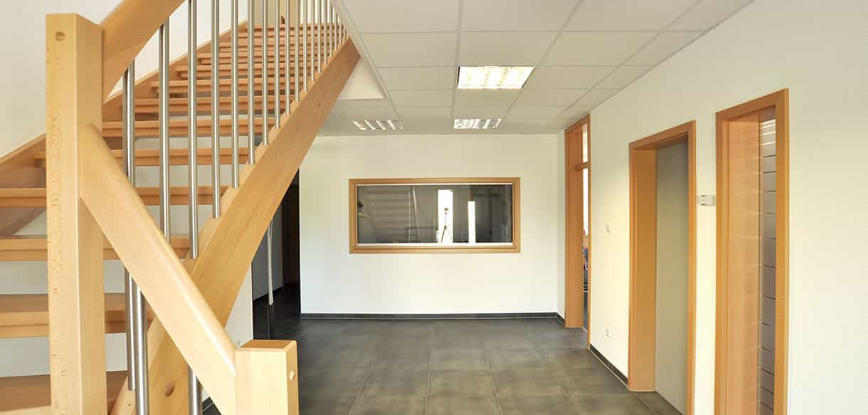 Holztreppe zum aufgestockten Obergeschoss im Bürogebäude des Metallwaren-Herstellers