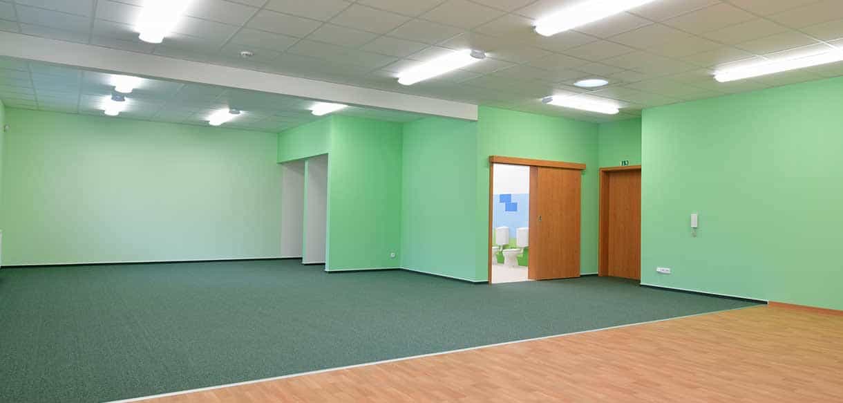 Grün gestrichener Gruppenraum mit Holzboden im Kindergarten Roztoky