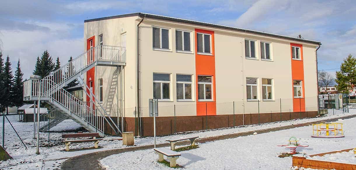 Außentreppe und verschneiter Spielplatz am Kindergarten Äpfelchen in Velké Přílepy