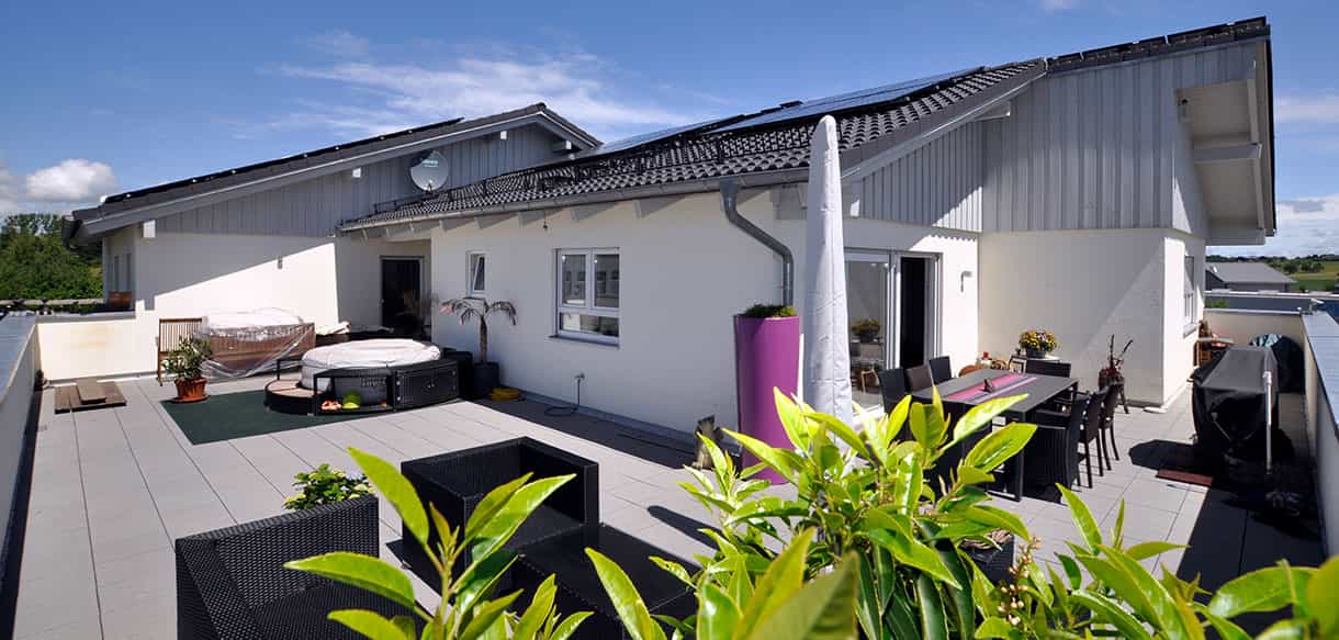 Dachterrasse der Wohnung über der Arcus Physiotherapiepraxis mit Loungemöbeln und Pflanzkübeln