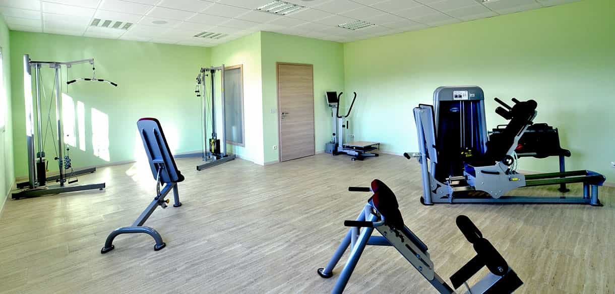 Trainingsraum der Physiotherapiepraxis Zielke mit Geräten und grünen Wänden