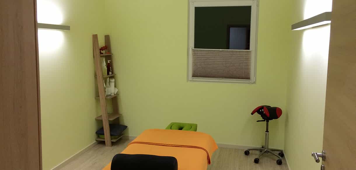 Behandlungsraum der Physiotherapiepraxis Zielke mit Liege und grünen Wänden