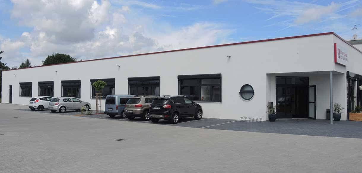 Parkplatzseite von Life Fitness Rödermark mit weißer Fassade und Fensterreihe