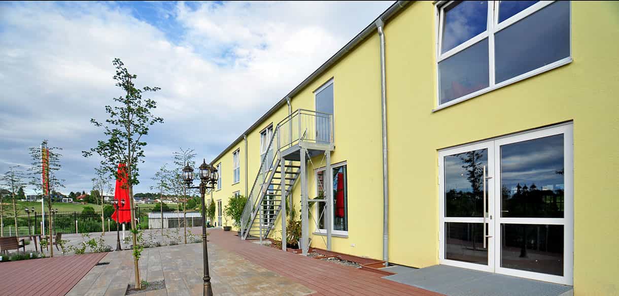 Gelbe Fassade mit Außentreppe am Kibungu Indoor-Spielparadies in Wurmberg