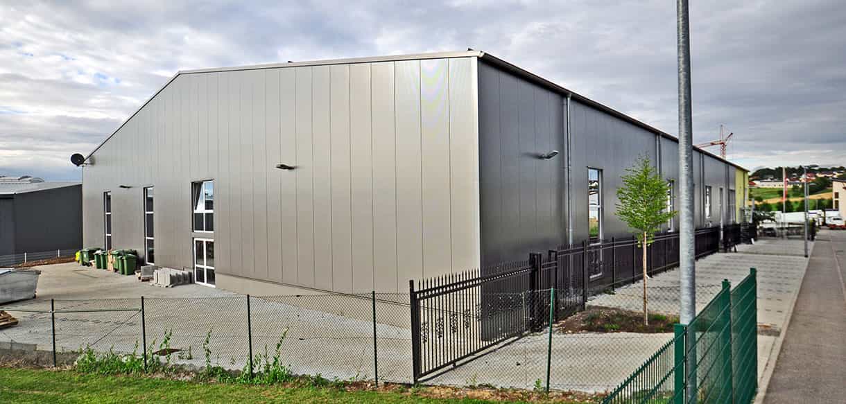 Rückseite der Spielhalle Kibungu in Wurmberg mit grau-weißer Metallfassade und Zaun