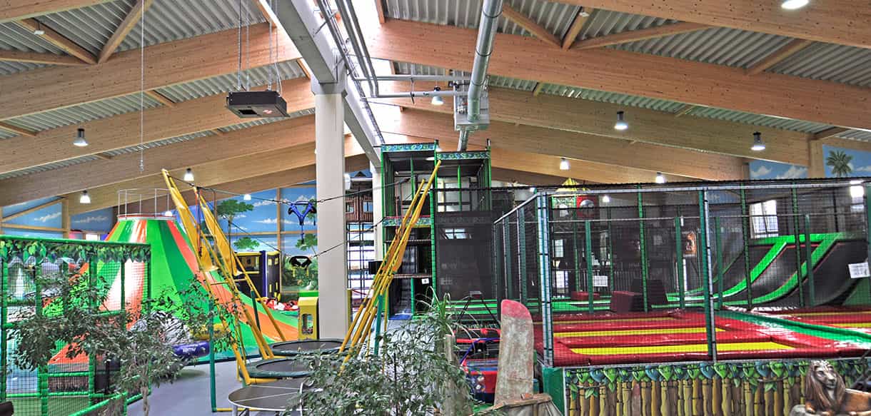 Spielhalle Kibungu mit Trampolinen, Klettergerüst und Holzleimbindern im Dach