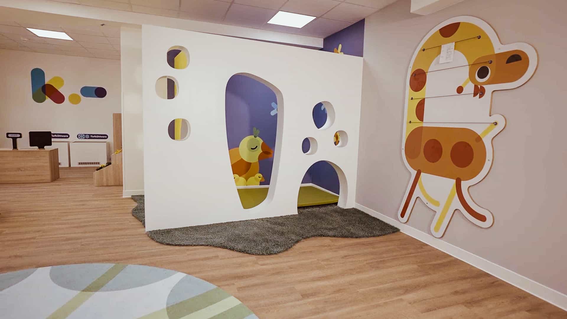 Spielhäuschen mit runden Öffnungen und Giraffen-Motiv in der Kita Hamburg von Haas Gewerbebau