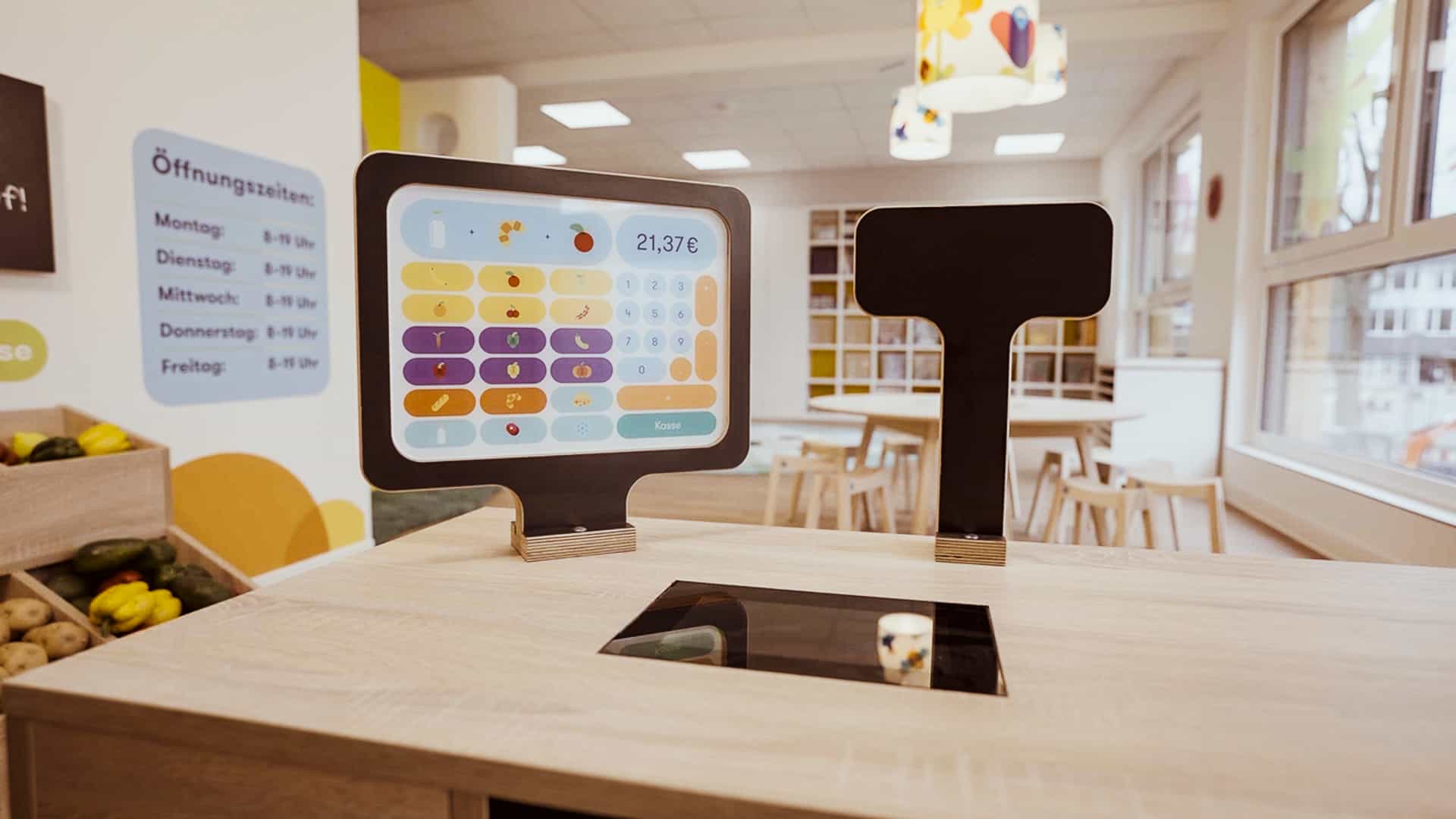 Spielkaufladen mit Kasse und Öffnungszeiten-Tafel in der Kita von Klüver & Kompanie Hamburg