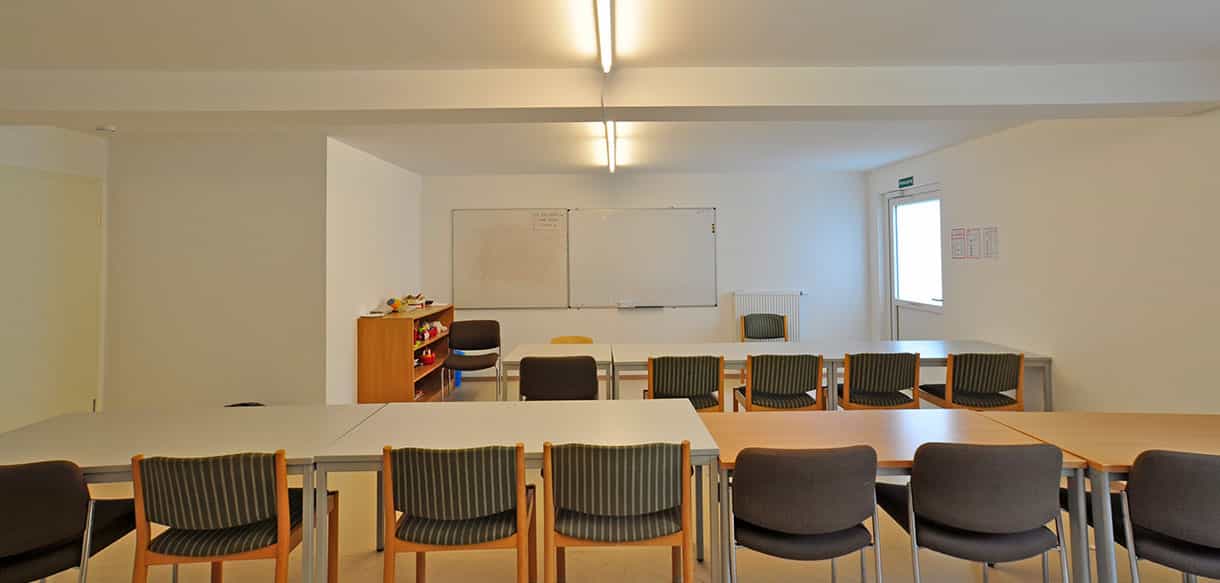 Gemeinschaftsraum mit Tischen, Stühlen und Whiteboard im Wohnheim in Neunkirchen am Sand