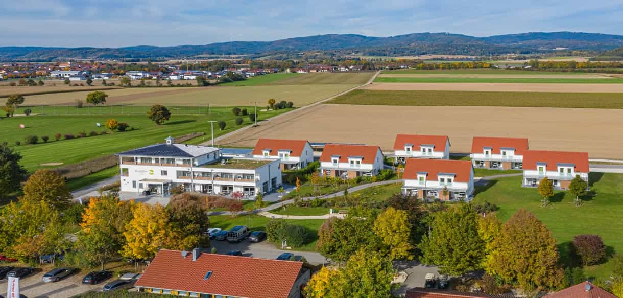 Luftaufnahme der Haas Referenz Bachhof mit mehreren Gebäuden zwischen Feldern, Beispiel Gästehaus bauen