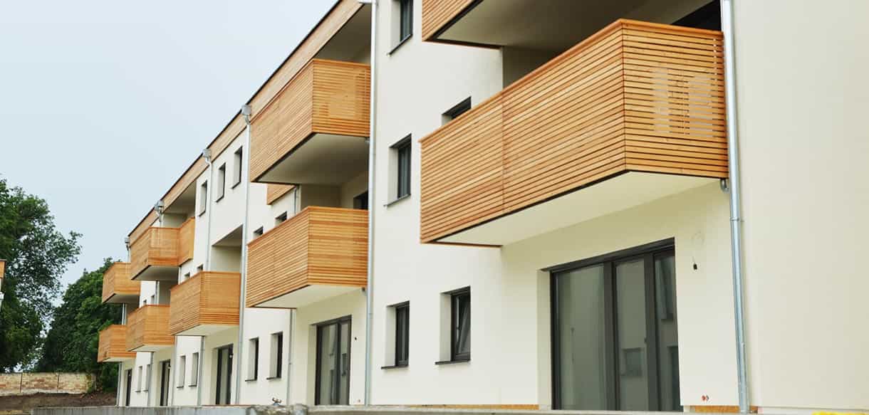 Holzverkleidete Balkone an der weißen Fassade der Wohnhausanlage mit 14 Wohnungen in Mistelbach
