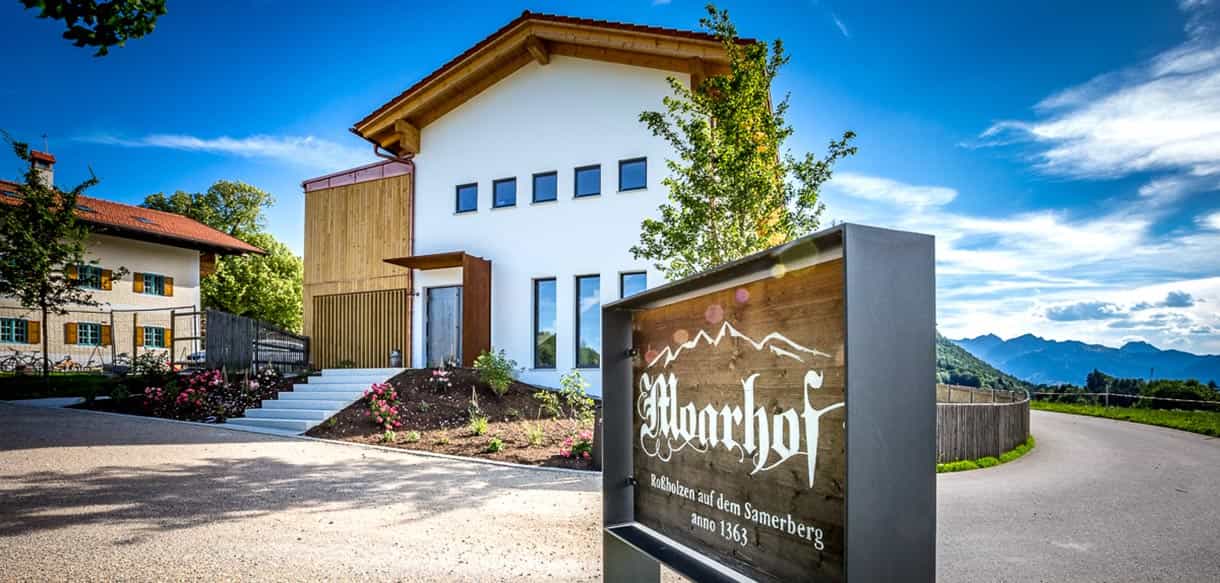 Eingang der Pension Moarhof mit Schild und Holzverkleidung, 14 Zimmer im ländlichen Stil von Haas