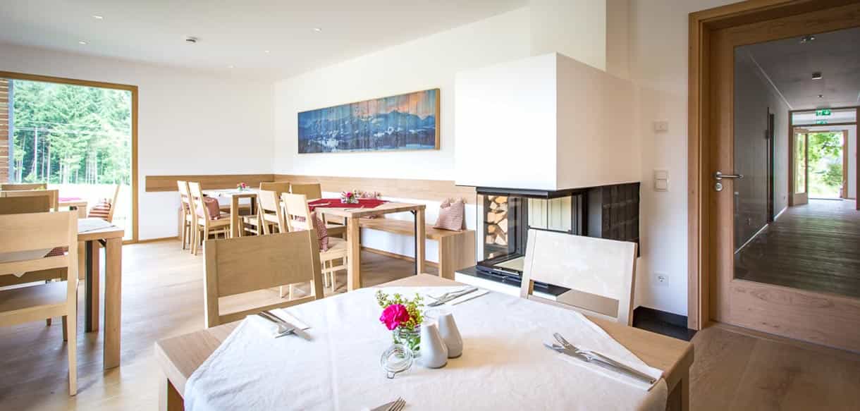 Frühstücksraum mit gedeckten Tischen und Holzmöbeln in der Pension Moarhof von Haas Fertigbau