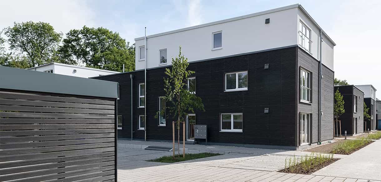 Wohnhaus im Donau-Wohnpark mit Holzfassade und Carport im Vordergrund, Referenz von Haas Wohnbau