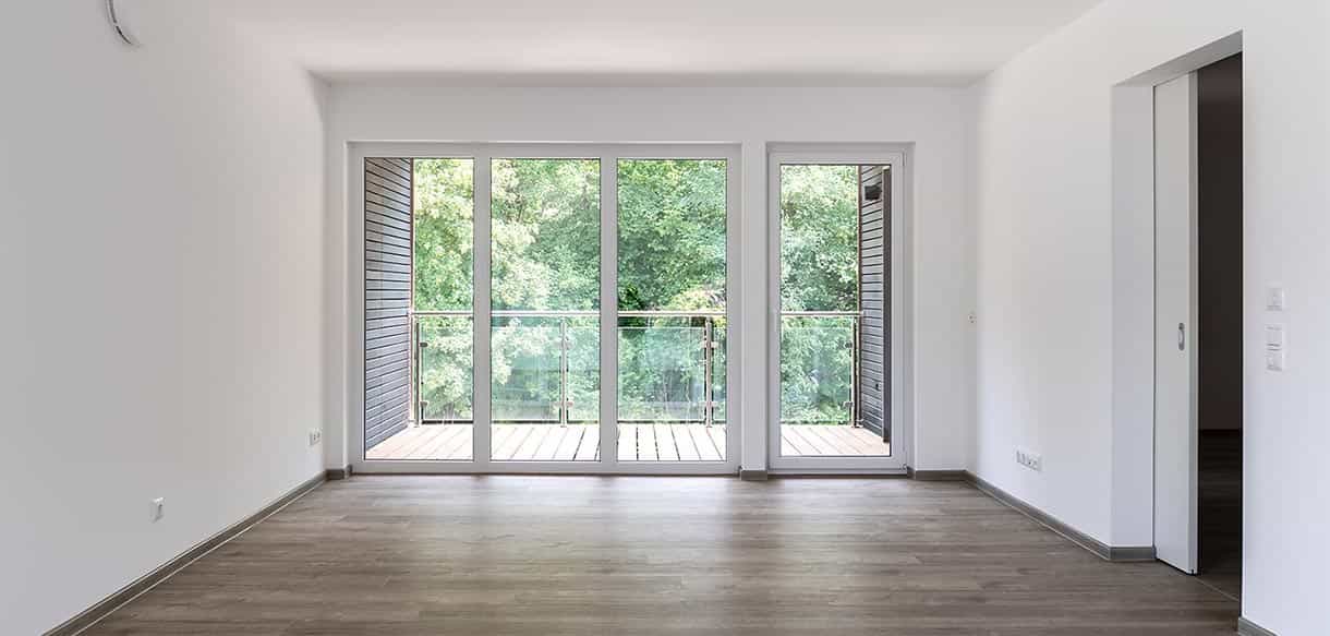 Wohnzimmer mit breiter Balkontür und Holzboden in einer Wohnung des Donau-Wohnparks